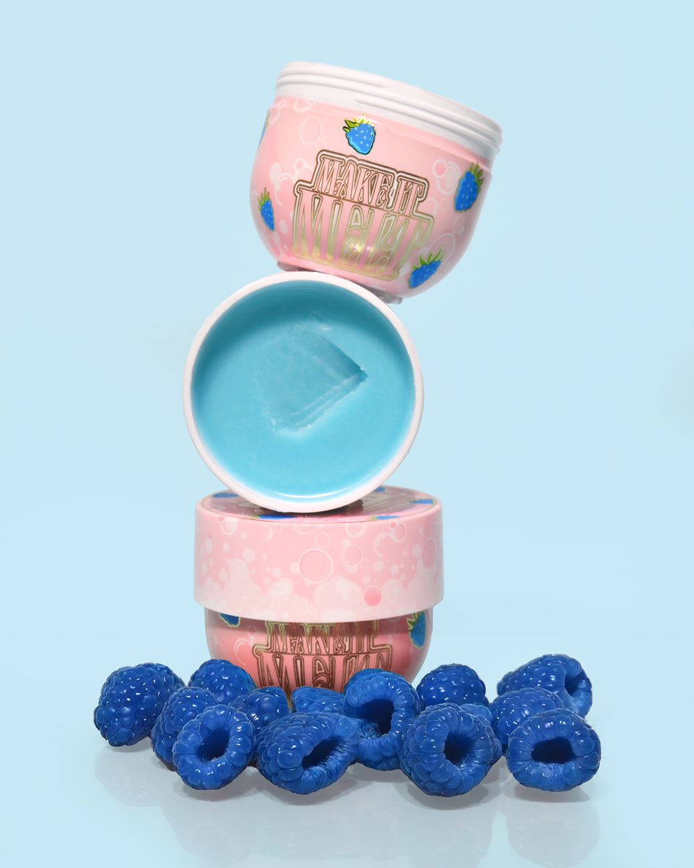 3 potjes P. Louise Make It Melt Makeup Removal Cleansing Balm in blauwe framboos op elkaar met de middelste open met blauwe crème omringd door blauwe frambozen op een blauwe achtergrond