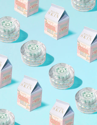 Clear containers of P.Louise Dose of Dreams Vitamin C Capsule Cream with blue capsule within them surrounded by  milk cartons