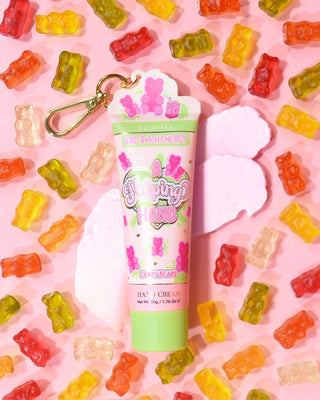 Tube of P. Louise A Helping Hand Hand Cream with colourful gummy bears on a pink background
