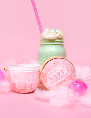 Open tub of P. Louise Make It Melt Makeup Cleansing Balm surrounded by candy floss on a pink background