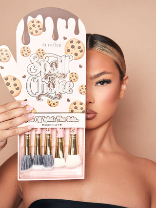 An image of the P.Louise Spoilt For Choice 5 Piece Makeup Brush Set in an oven mitt packaging box with a tray pulled out the bottom showing the brushes partially. The packaging is showing half a models face wearing makeup