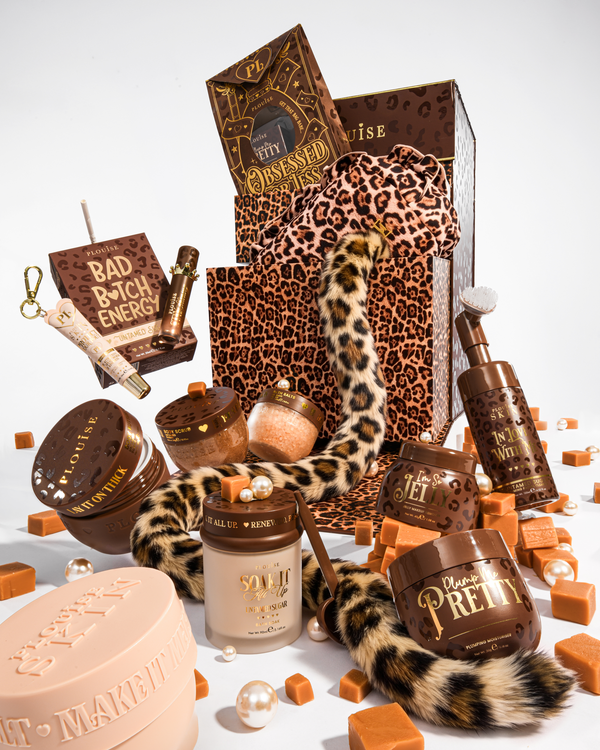 Een luxe beautycadeauset met bruine en luipaardprintelementen, waaronder een cadeauzakje met luipaardprint, een staart met luipaardprint en meerdere cosmetische containers in bruine en beige tinten, gerangschikt op een witte achtergrond met karamelkleurige blokjes en parels.