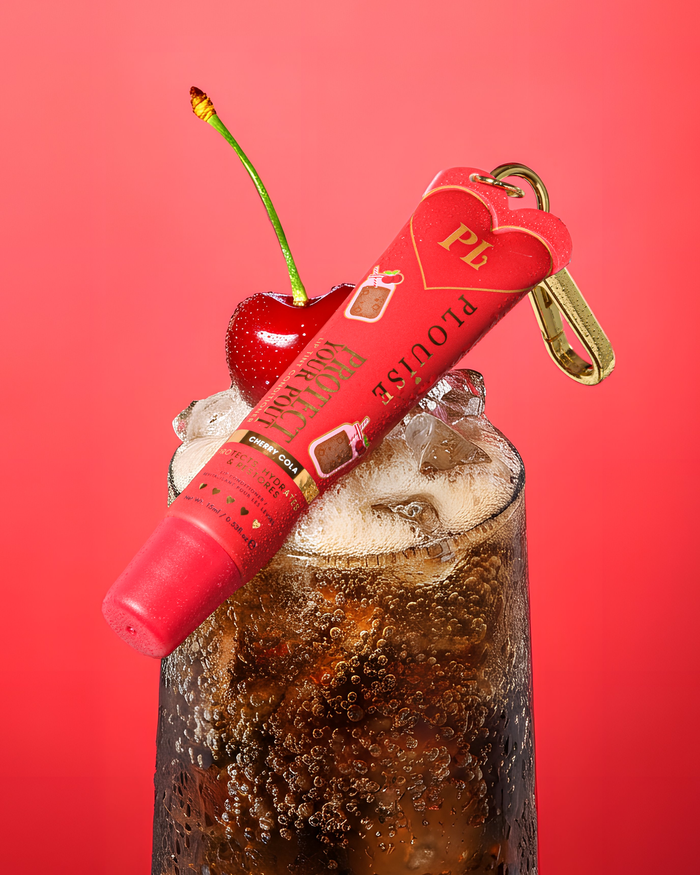 Rode kersen-cola-geur getinte bescherm je pruillip-conditioner met gouden clip bovenop een glas kersen-cola met een kers