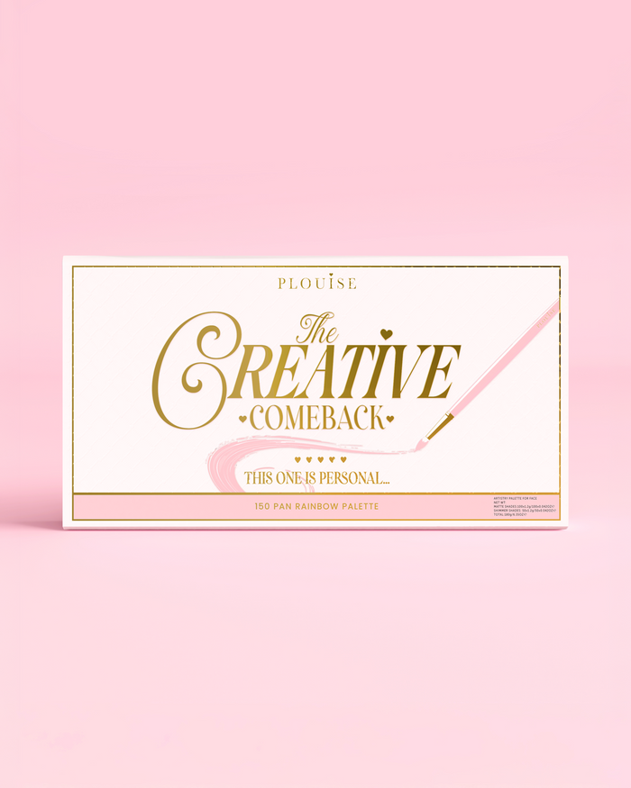De voorkant van een gesloten P.Louise Creative COMeback XXXL Rainbow Eyeshadow Palette met gouden typografie op een roze hoesje tegen een roze achtergrond