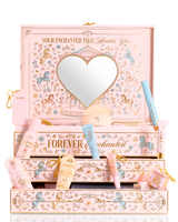 A P.Louise pastel pink, blue and yellow Christmas PR beauty gift set box labelled 'Your Enchanted Tale' with a heart-shaped mirror on the lid and open drawers, surrounded by assorted cosmetic tubes, bottles, and a small pouch on a white background.