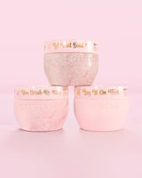Three P.Louise Hop Into Self-Care Pink Marshmallow pink containers featuring bath salts, body scrub and body butter with gold text on a pink background