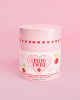 Een roze verpakking P.Louise Plot Twist Makeup Melting Cleansing Balm met hart- en kersenmotieven op het etiket tegen een roze achtergrond