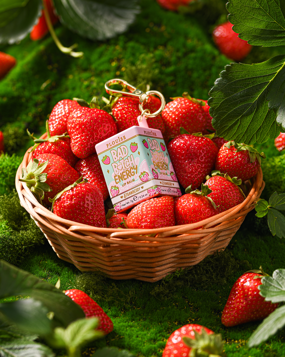 P.Louise Strawberry keychain lip balm in a basket with strawberries