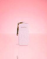 Roze fles P.Louise Hand Sanitiser Spray in kenmerkende geur met gouden sleutelhanger op een roze achtergrond