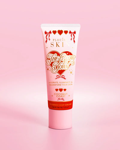 Pink tube of P.Louise The Glow Down shimmer body cream in coconut coast scent against a pink background