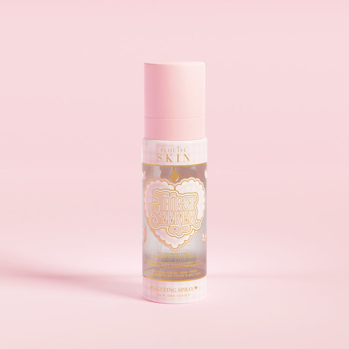 Een roze spuitfles met het opschrift 'P.Louise SKIN' met een afbeelding van een hart en enkele bloemige elementen, met daarin een hydraterende setting spray.