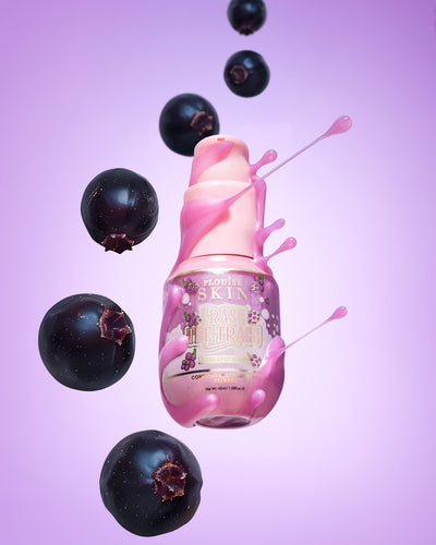 Roze flesje P. Louise Erase The Trace Dark Spot Correcting Serum met vloeistof uit de fles omringd door zwarte bessen op een paarse achtergrond