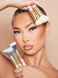 Een afbeelding van een vrouwelijk model dat make-up draagt en de P.Louise Spoiled For Choice 5-delige make-upborstelset tegen haar gezicht houdt