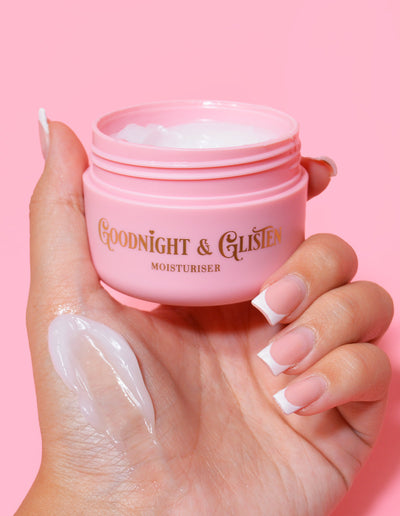 Een hand die een roze potje P.Louise Goodnight & Glisten Gel Moisturizer vasthoudt met wat vochtinbrengende crème zichtbaar op de huid.